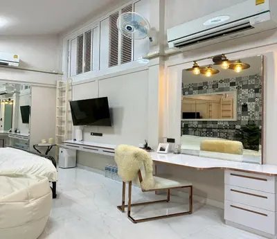 a bedroom with a desk and a mirror at Residence at 49 in Bangkok