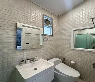 a bathroom with a toilet and a sink and a window at Residence at 49 in Bangkok
