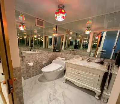 a bathroom with a toilet and a sink and mirrors at Residence at 49 in Bangkok