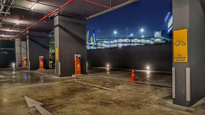 a parking garage with a view of a city at night at Plum New West - Pool View in Ban Bang Krabu