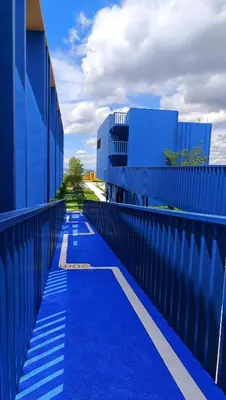a blue walkway next to a blue building at Plum New West - Pool View in Ban Bang Krabu