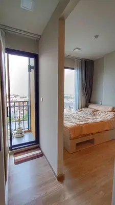 a bedroom with a bed and a large window at Plum New West - Pool View in Ban Bang Krabu