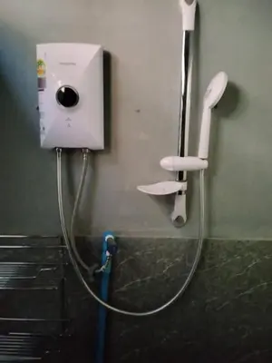 a shower head with a hose attached to a wall at The Green Bean Hostel Khaosan in Bangkok