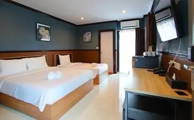 a bedroom with two beds and a flat screen tv at THE BRETON Hotel in Ban O Pao