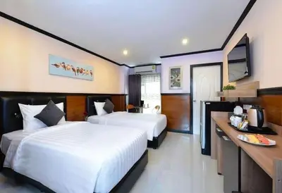 a hotel room with two beds and a television at THE BRETON Hotel in Ban O Pao