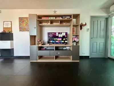 a living room with a television in a cabinet at Panoramic sky city view 1 BR at MRT Bangson By Orn in Bangkok