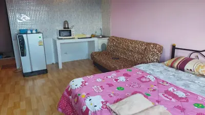a room with a bed and a couch and a refrigerator at Smart Residence@Muengthongthani in Nonthaburi