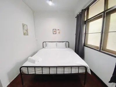 a bed in a white room with a window at BAO The Giant Swing - เบา ศาลเจ้าพ่อเสือ ถนนตะนาว in Bangkok