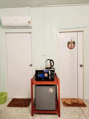 a small table with a microwave on it next to a door at 707-STP Homely room Free Wi-Fi and Near BTS in Sathani Bang Khen