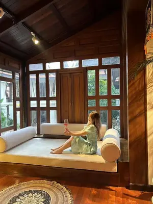 a little girl sitting on a bed in a room at CBD Private Pool Villa Nanny Free Thai costumes 24hrs Security Breakfast in Bangkok