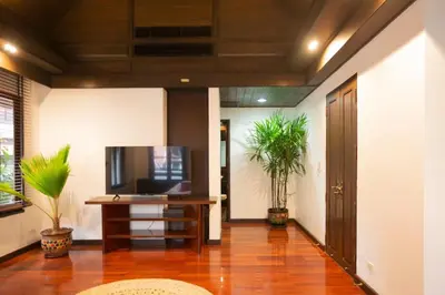 a hallway with a television and a table with plants at CBD Private Pool Villa Nanny Free Thai costumes 24hrs Security Breakfast in Bangkok