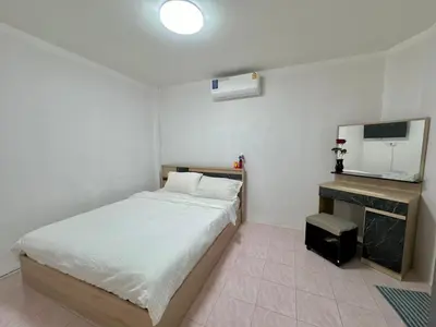 a small bedroom with a bed and a television at Baan Kalaya Homestay in Nonthaburi