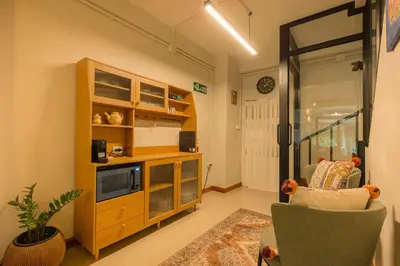 a living room with a tv and a couch at Oasis Thai Teak Home in Sathorn in Yan Nawa