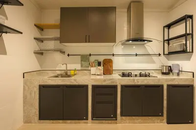 a kitchen with black cabinets and a sink at Oasis Thai Teak Home in Sathorn in Yan Nawa