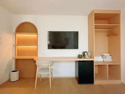 a room with a desk and a tv on a wall at Wynora Hotel in Khlong Toei