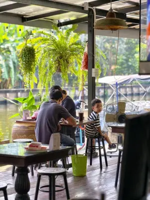 a man and a child sitting at a table in a restaurant at นำสมัย สุขใจ สนามชัย in Bangkok
