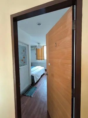 a room with a door and a bedroom with a bed at Santo house no66 in Bangkok