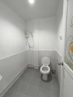 a white bathroom with a toilet and a shower at Santo house no66 in Bangkok
