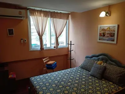 a bedroom with a bed with a blue bedspread and windows at Santo house no66 in Bangkok