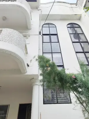 a white building with windows and a wreath on it at \u8f89\u714c\u62c9\u629b\u9644\u8fd13\u5ba4\u522b\u5885 in Ban Zong Katiam