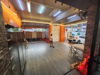 a person standing in a room with a table and a car at 101Hotel in Ban Na Song