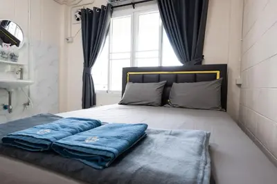 a bedroom with a bed with blue pillows on it at ดอนเมือง 301 Near DMK Airport BTS Wat PhraSi in Bang Khen