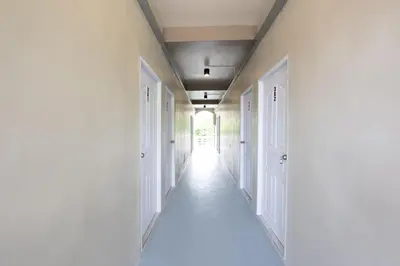 an empty hallway with white walls and white doors at ดอนเมือง 301 Near DMK Airport BTS Wat PhraSi in Bang Khen