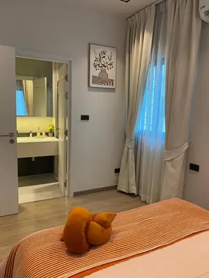 a stuffed animal laying on a bed in a bedroom at 89 Residence Ratchada - Rama 9 in Ban Na Song