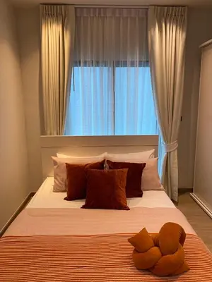 a bed with a teddy bear laying on top of it at 89 Residence Ratchada - Rama 9 in Ban Na Song