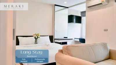 a hotel room with a bed and a vase of flowers at 5 mins to BTS Ekkamai, One Bed Fully-Furnished in Bangkok