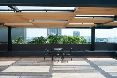 a table and chairs on the roof of a building at 5 mins to BTS Ekkamai, One Bed Fully-Furnished in Bangkok