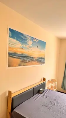 a bedroom with a bed with a painting on the wall at \u8f89\u714c\u62c9\u629b3\u5ba4180\u5e73\u7c73\u522b\u5885 in Bangkok