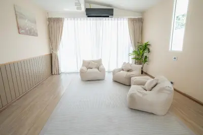 a living room with two white chairs and a large window at Stay Ekkamai - Private Pool villa, Central Bangkok in Bangkok