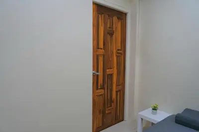 a wooden door in the corner of a room at 38 House Don Mueang Airport BTS Wat Phrasi in Bang Khen