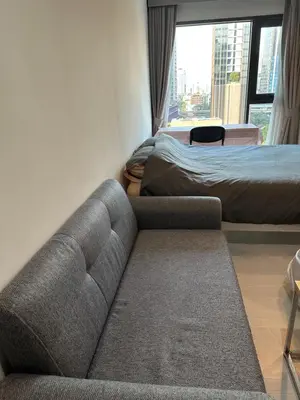a living room with a couch and a bed at BTS Skytrain Thonglor station sukhumwit 36-38 in Bangkok