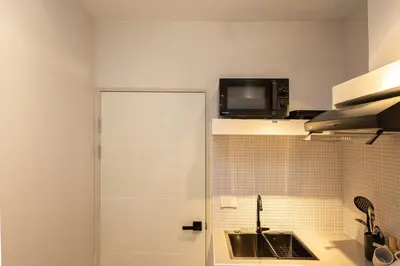 a kitchen with a sink and a microwave at Cute & Comfy Studio for 3 guests at Center of Sathorn in Bangkok