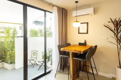 a dining room with a wooden table and chairs at Cute & Comfy Studio for 3 guests at Center of Sathorn in Bangkok