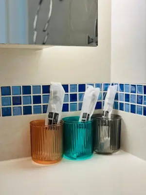 three toothbrushes in buckets on a bathroom counter at Page65-Bangkok Urban Light & City Rhythm -Ekkamai in Bangkok