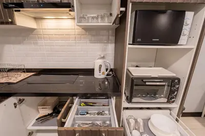 a small kitchen with a microwave and a refrigerator at Hangover State Tower Stunning River View in Bangkok