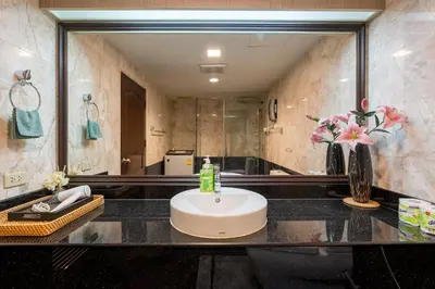 a bathroom with a sink and a large mirror at Hangover State Tower Stunning River View in Bangkok