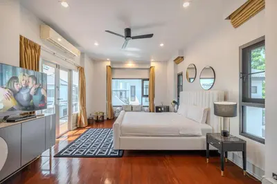 a bedroom with a white bed and a tv at Thong Lo Private Pool Villa In Center Of Bangkok in Bangkok