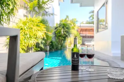 a bottle of wine sitting on a table with two glasses at Thong Lo Private Pool Villa In Center Of Bangkok in Bangkok