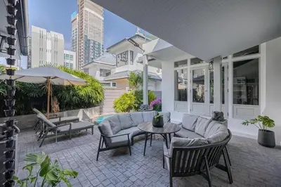 a patio with a couch and chairs and a table at Thong Lo Private Pool Villa In Center Of Bangkok in Bangkok