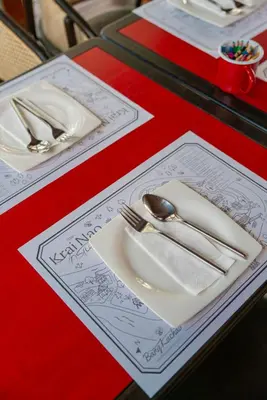 a table with a plate with a fork and spoon at Baan Krai Nao The Riverfront in Bang Chak