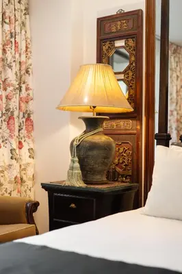 a lamp sitting on a table next to a bed at Star House Classic Style in Bangkok