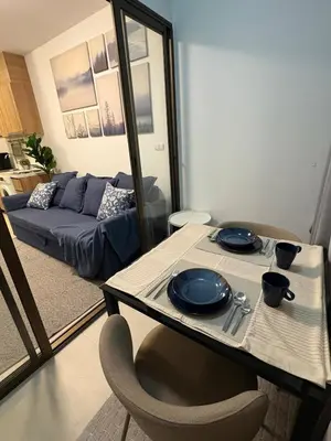 a living room with a table and a couch at Ideo Mix Sukhumvit 103, right next to BTS Udomsuk in Phra Khanong