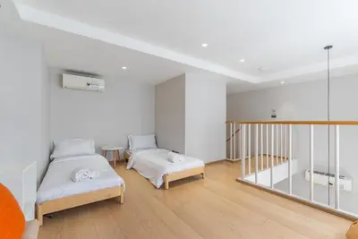 a white room with two beds and a staircase at Heart \u7d20\u5764\u903836 Chewaheart Sukhumvit 36 in Bangkok