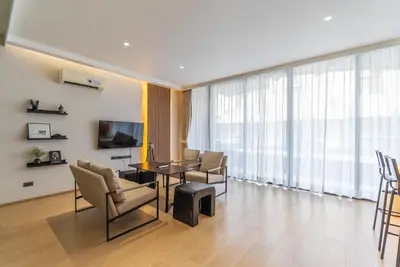 a living room with a table and chairs and a television at Heart \u7d20\u5764\u903836 Chewaheart Sukhumvit 36 in Bangkok