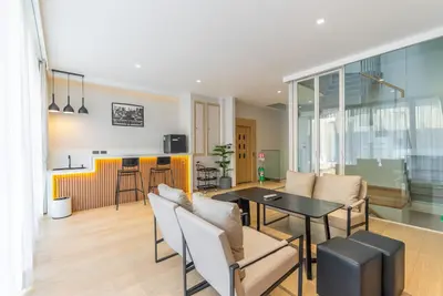 a living room with a table and chairs at Heart \u7d20\u5764\u903836 Chewaheart Sukhumvit 36 in Bangkok