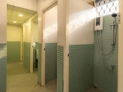 a bathroom with green striped walls and a shower at Social Pod Khao San Hostel in Bangkok